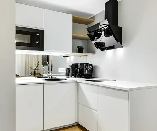 a kitchen with white cabinets and black appliances