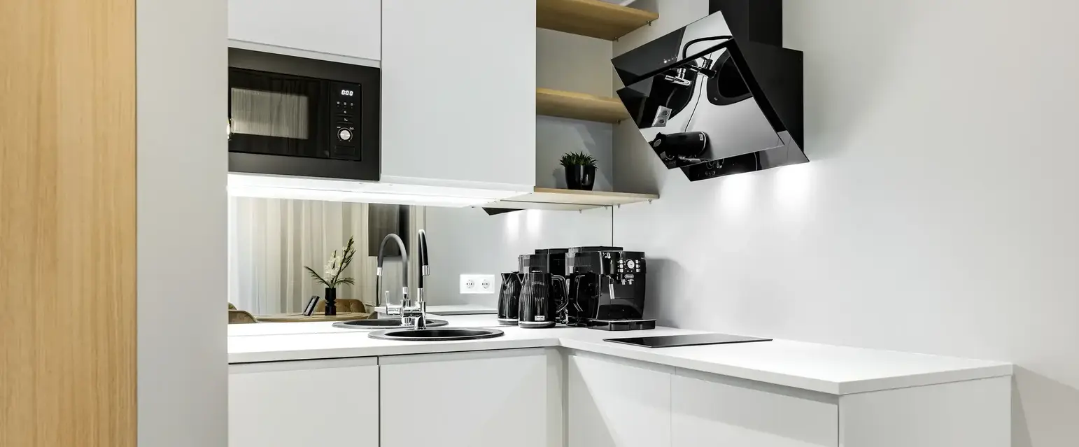 a kitchen with white cabinets and black appliances