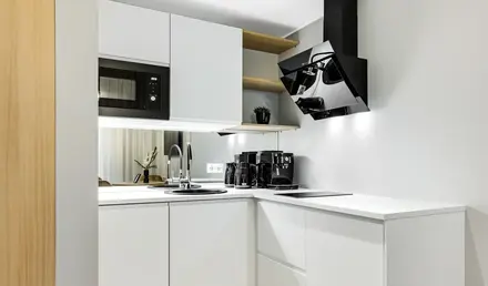 a kitchen with white cabinets and black appliances
