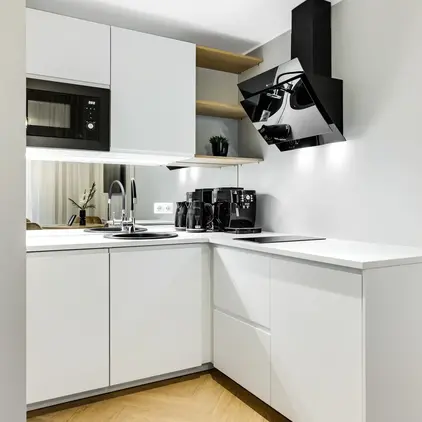 a kitchen with white cabinets and black appliances