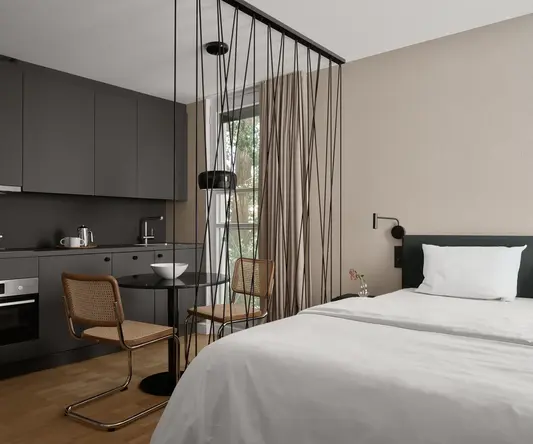 a room with a bed and chairs