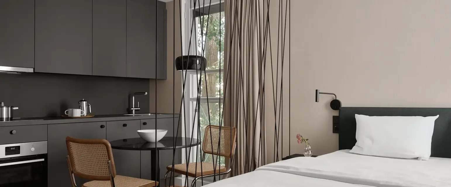 a room with a bed and chairs