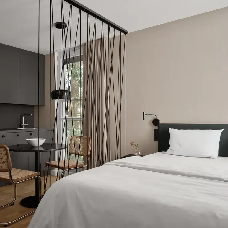 a room with a bed and chairs