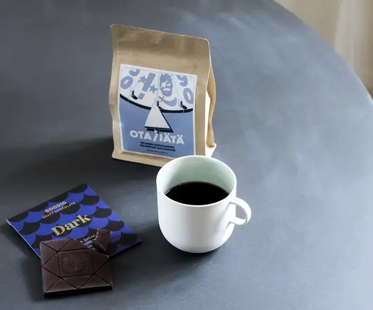 a cup of coffee and a bag of coffee on a table