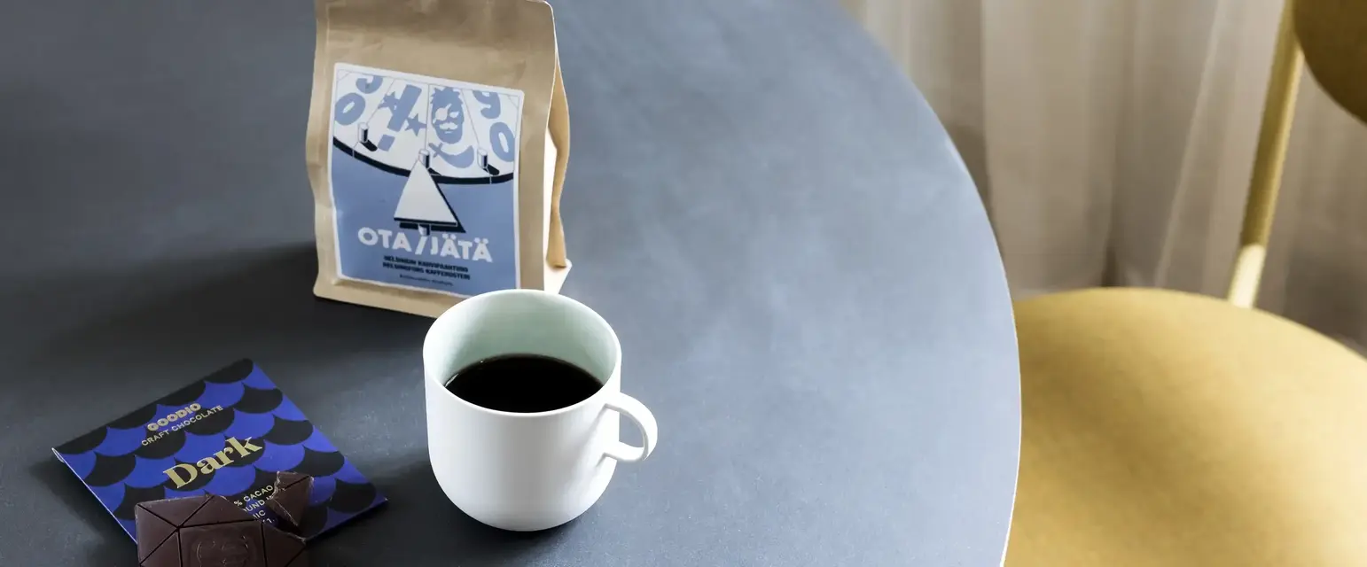 a cup of coffee and a bag of coffee on a table