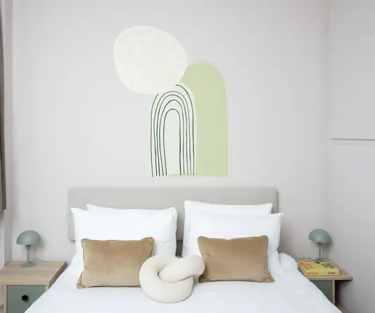 a bed with pillows and a wall art
