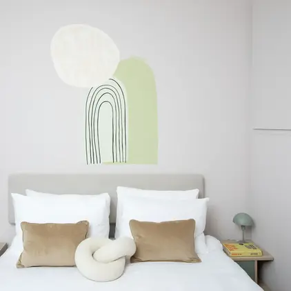 a bed with pillows and a wall art