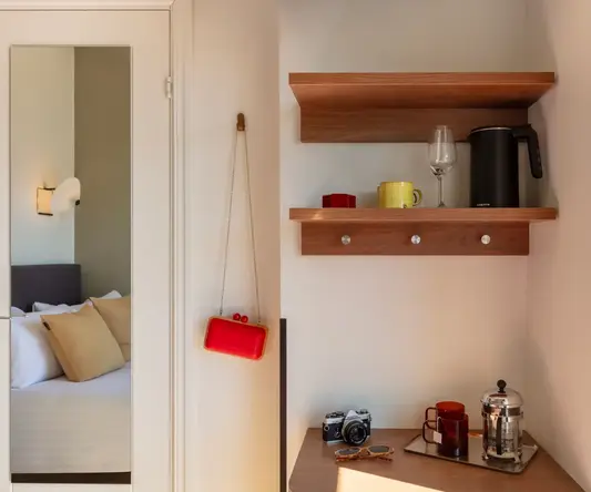 a shelf with coffee cups and a camera on it