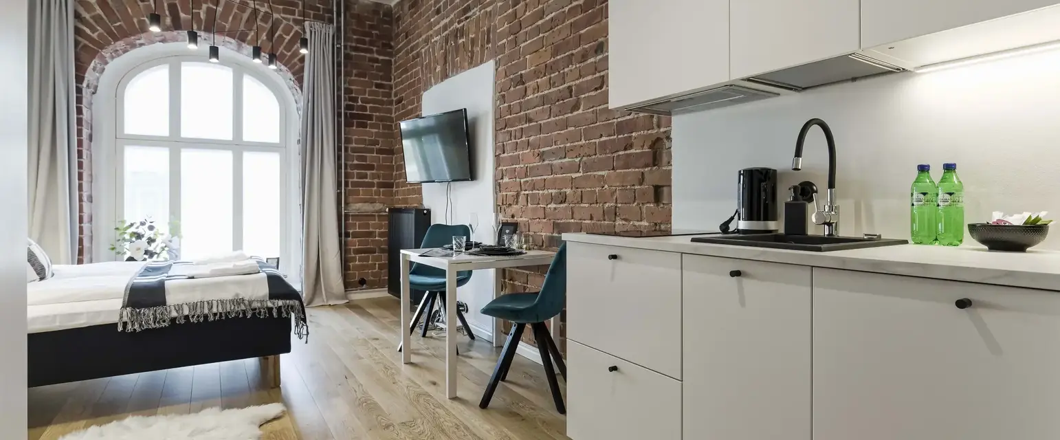 a room with a brick wall and a bed and a table