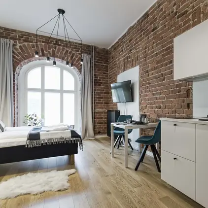 a room with a brick wall and a bed and a table