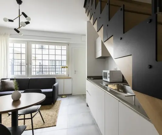 a kitchen with a staircase and a couch