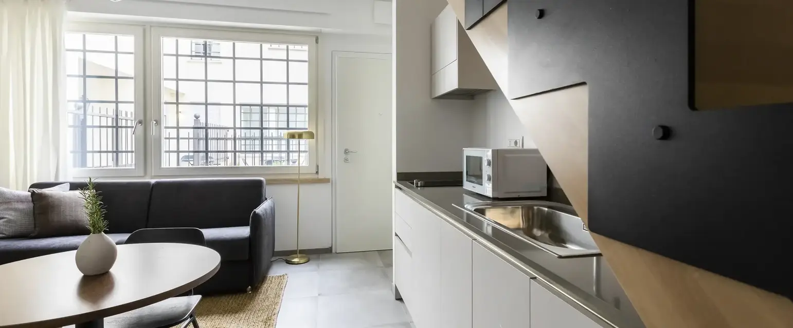 a kitchen with a staircase and a couch