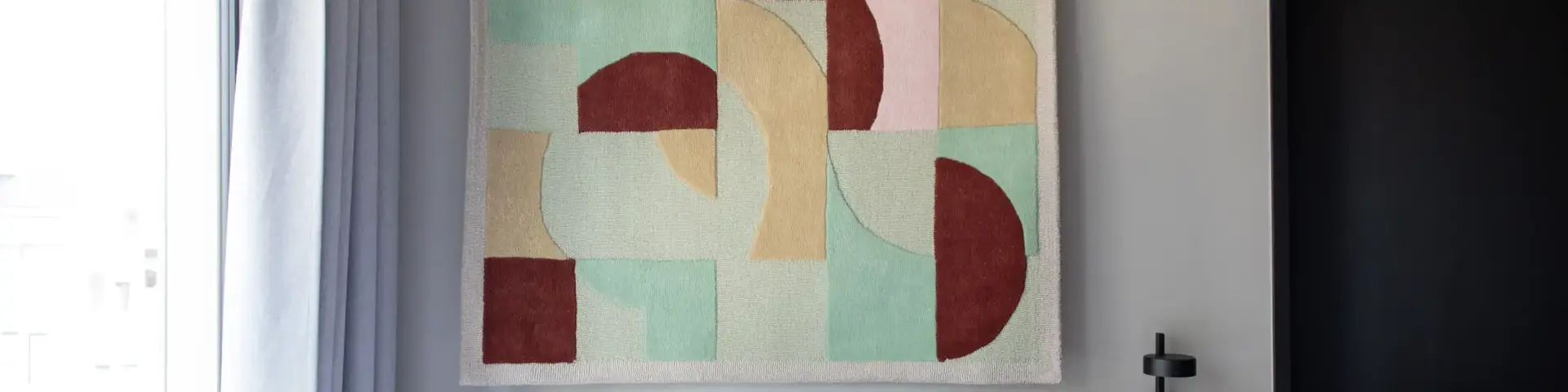 a bed with pillows and a piece of art on the wall