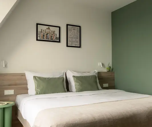 a bed with green pillows and a green wall