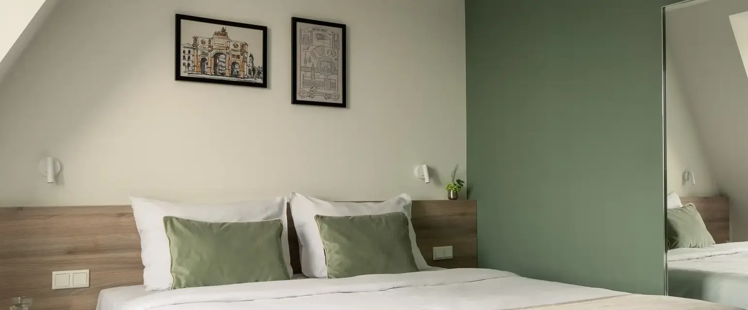 a bed with green pillows and a green wall