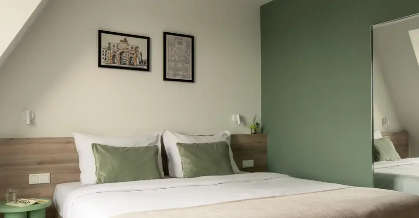 a bed with green pillows and a green wall