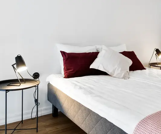 a bed with pillows and a lamp