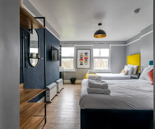 a room with two beds and a tv