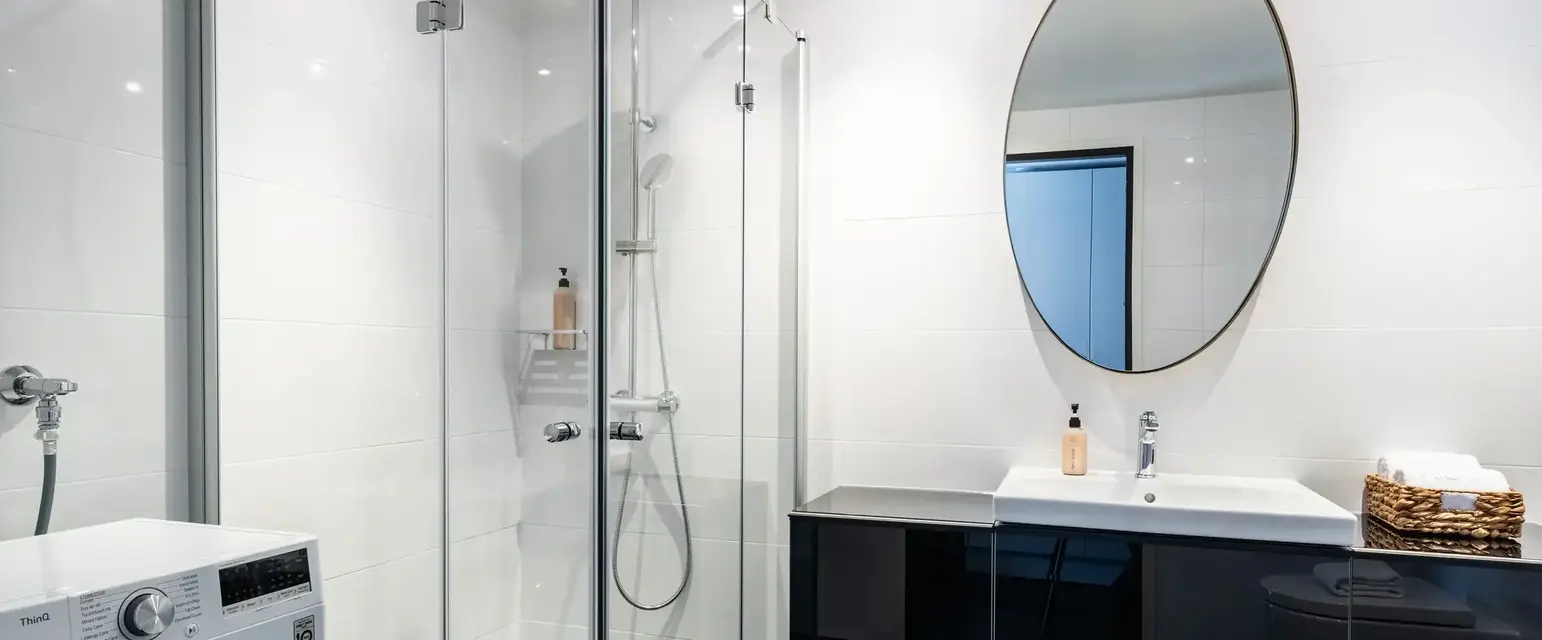 a bathroom with a shower and a washing machine