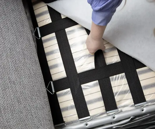 a person placing a mattress on a couch