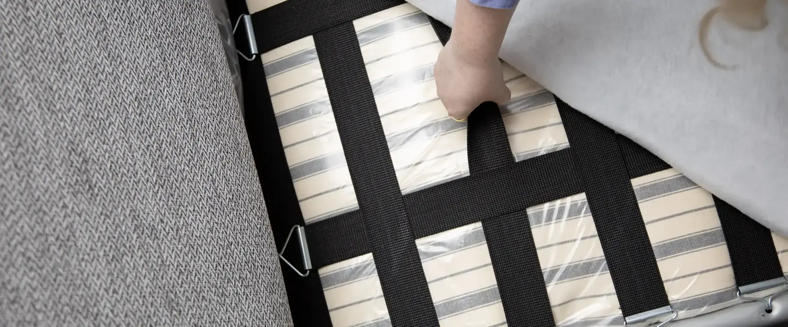a person placing a mattress on a couch