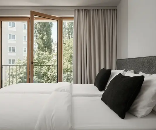 a bed with white sheets and black pillows