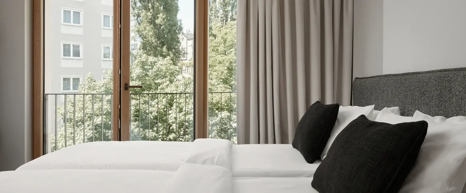 a bed with white sheets and black pillows