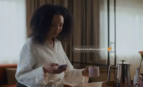 a woman in a white robe holding a cup and a phone