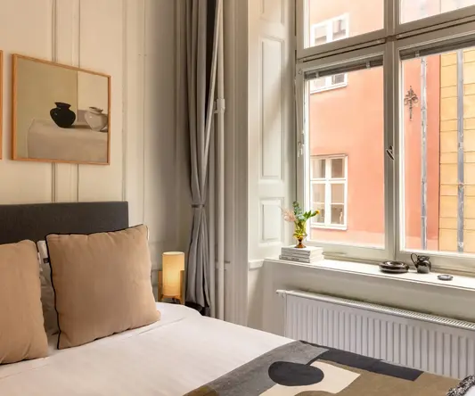 a bed with a window and a picture of a building outside