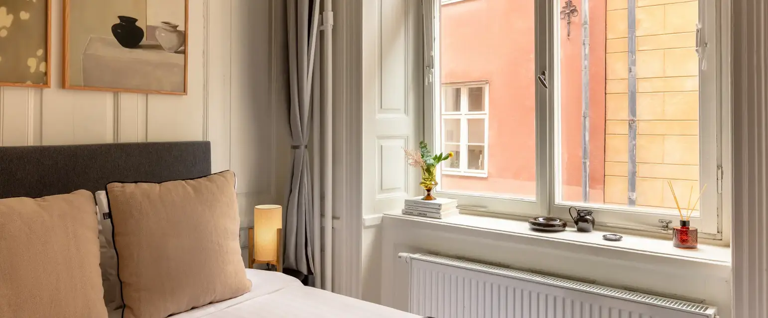 a bed with a window and a picture of a building outside