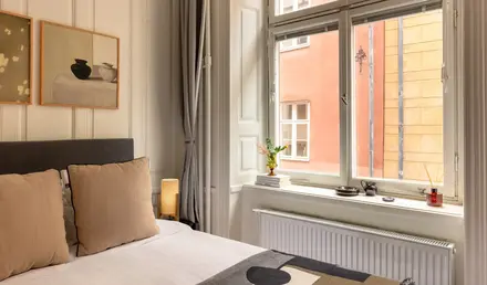 a bed with a window and a picture of a building outside