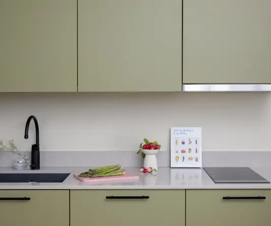 a kitchen counter with a sink and a cutting board