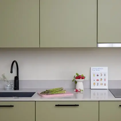 a kitchen counter with a sink and a cutting board