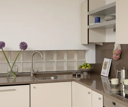 a kitchen with a sink and a bowl of fruit