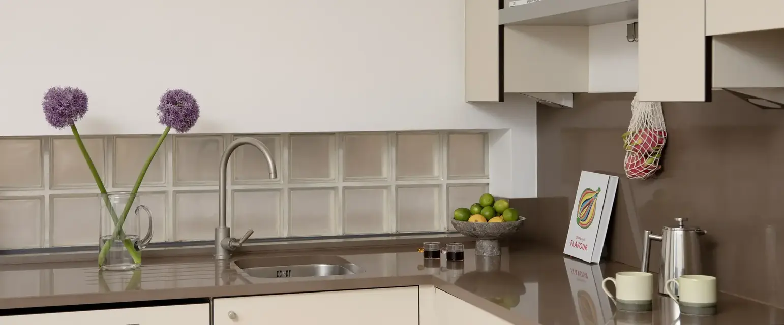 a kitchen with a sink and a bowl of fruit