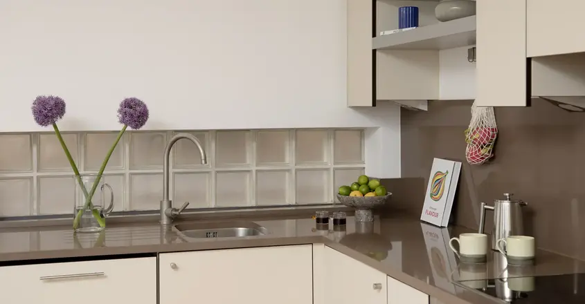 a kitchen with a sink and a bowl of fruit