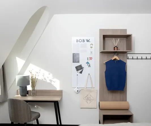 a room with a desk and a chair and a blue shirt