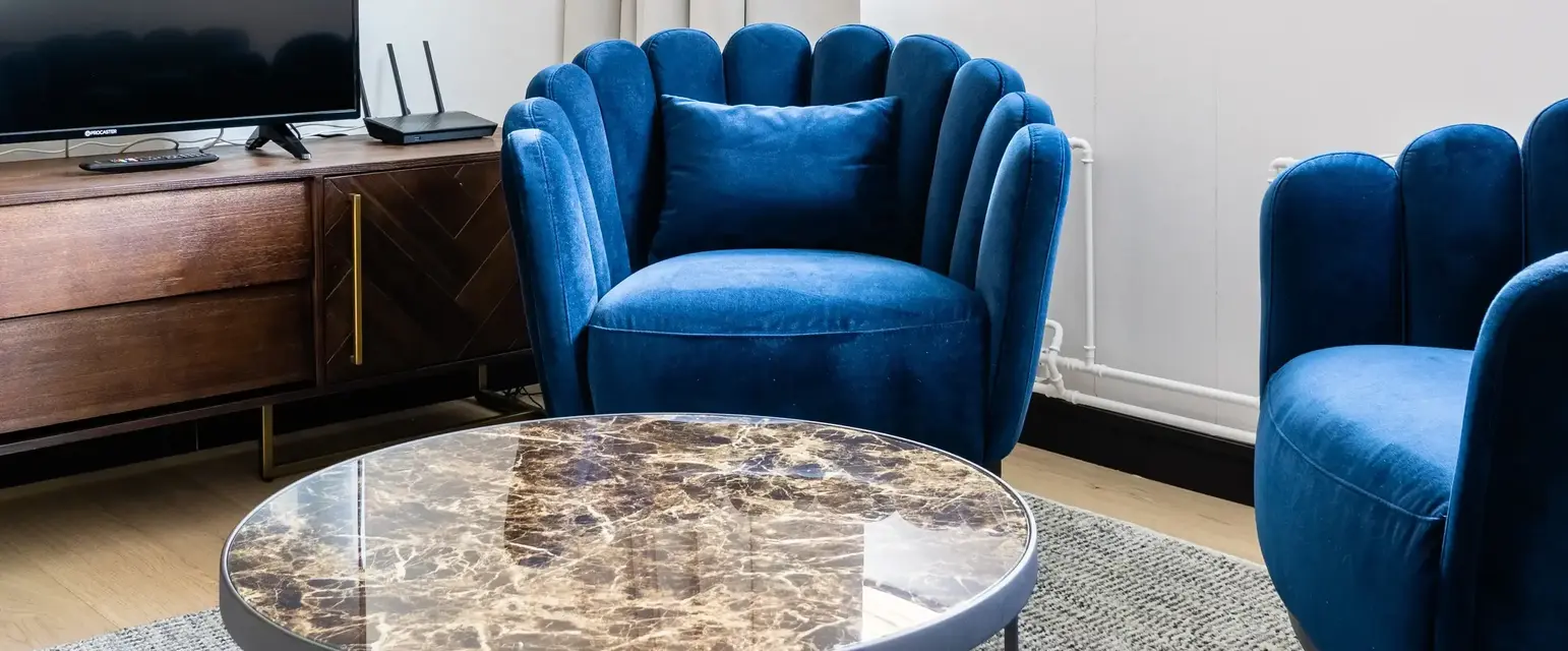 a living room with blue chairs and a television