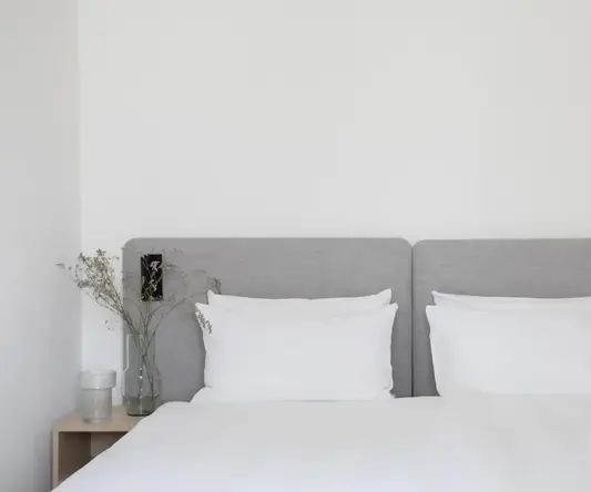 a bed with white sheets and a lamp