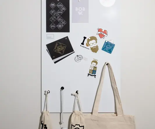 a white board with a white sign and a white bag on a white wall