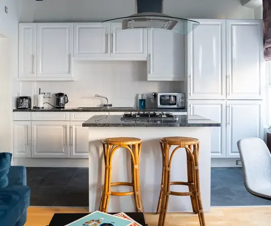 a kitchen with white cabinets and a blue couch