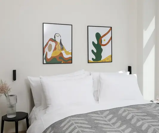 a bed with pillows and a picture on the wall