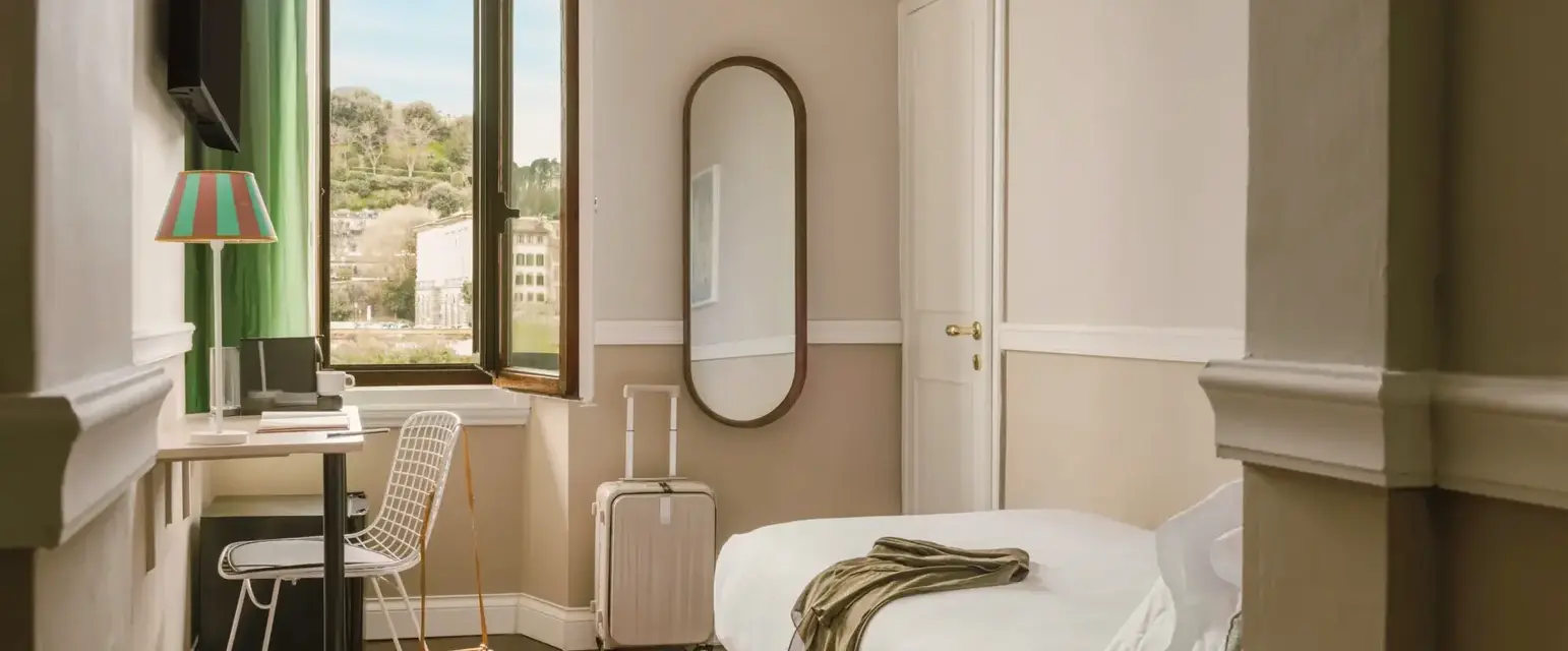 a room with a bed and a desk and a mirror