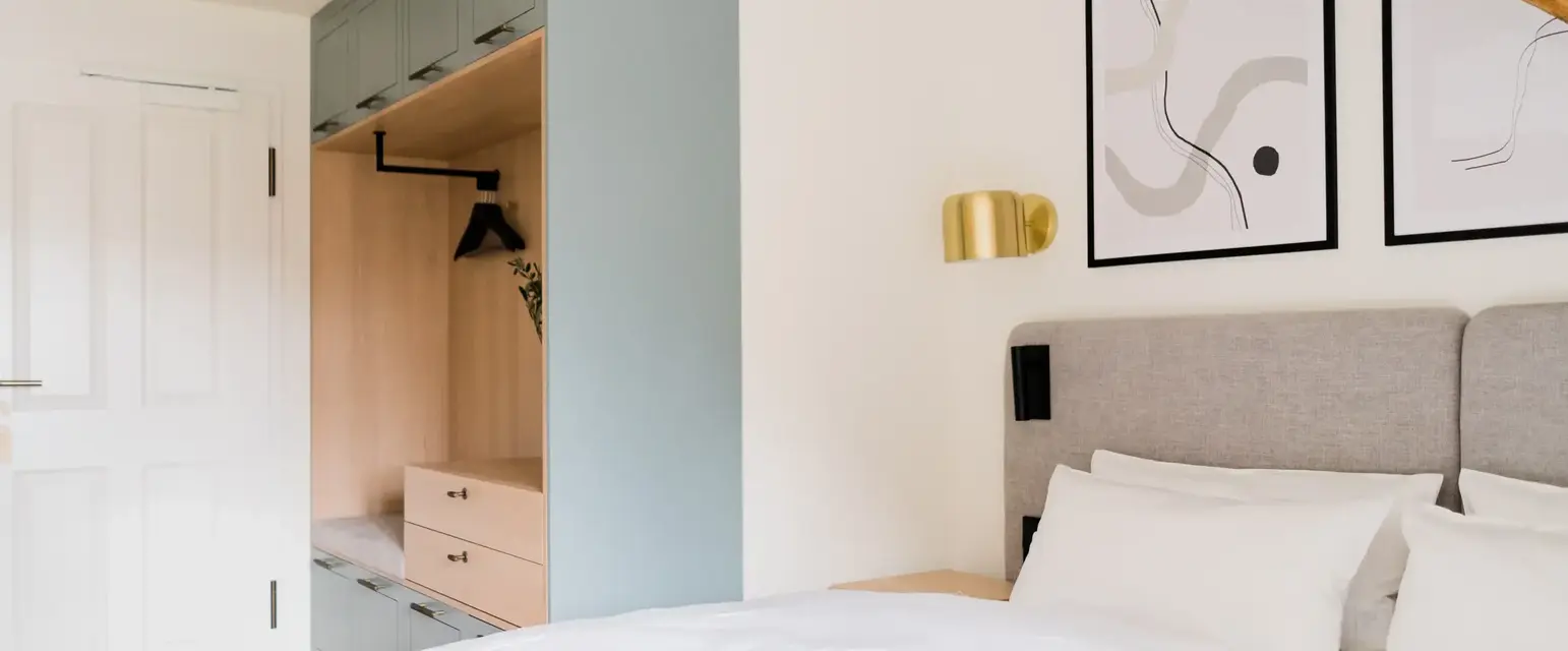 a bed with white pillows and a blue cabinet