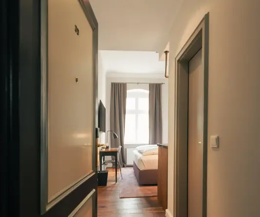 a hallway with a bed and a desk