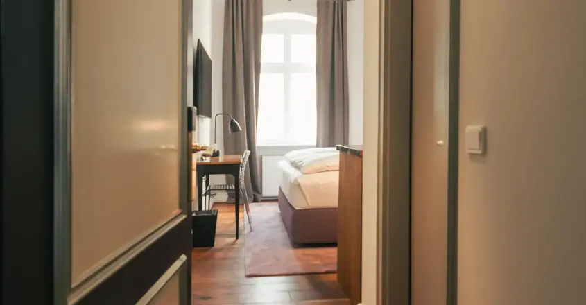 a hallway with a bed and a desk