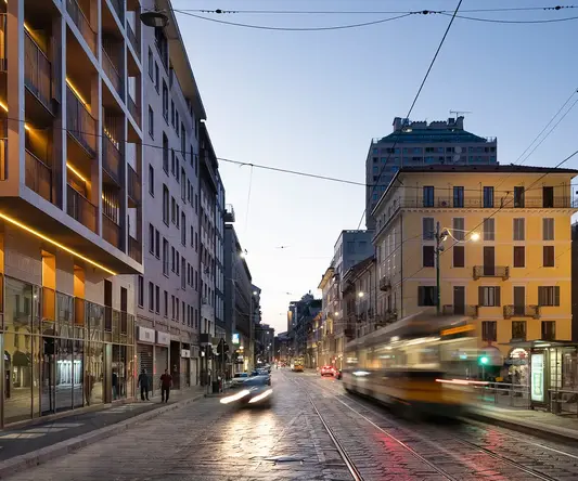 a street with buildings and a train moving on it
