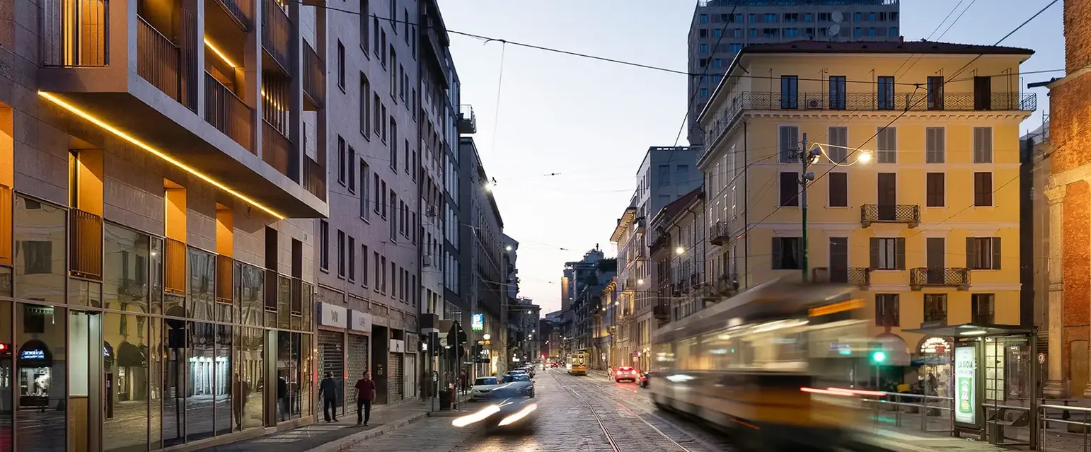a street with buildings and a train moving on it