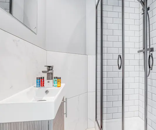 a shower with a sink and a towel on the side