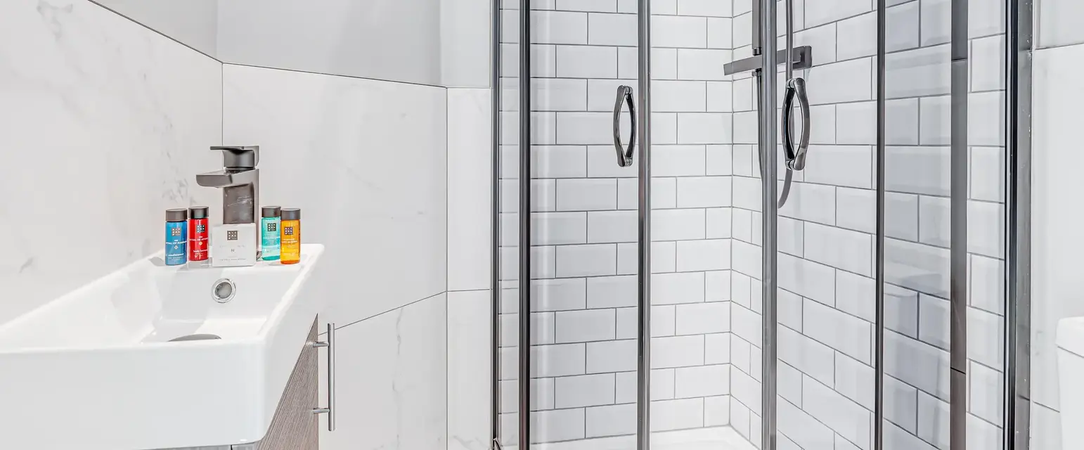 a shower with a sink and a towel on the side